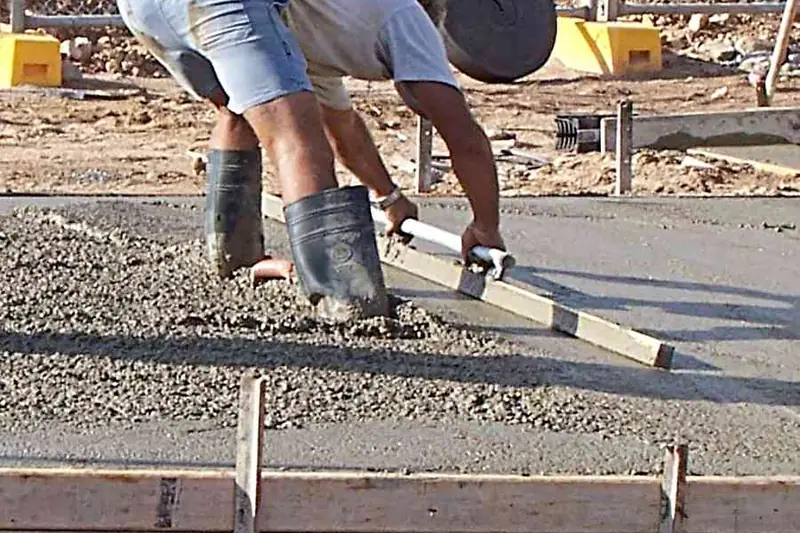 Açık alanda kalıp içine dökülen bahçe betonunun mastarla düzeltilmesi